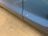a close up of a blue car with a hole in the side