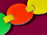 a close up of a colorful necklace on a purple surface