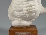 an image of a sculpture of a snail on a wooden base
