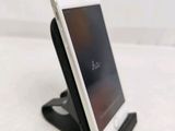 an iphone is sitting on a stand on a white surface