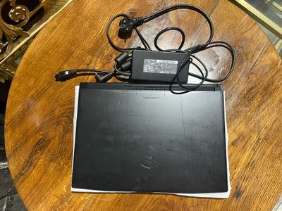 a laptop computer sitting on top of a wooden table