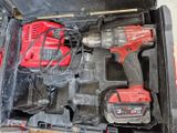 a red drill and two other tools in a tool box
