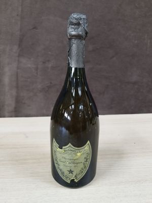 une vieille bouteille de champagne posée sur une table en bois, sur fond marron