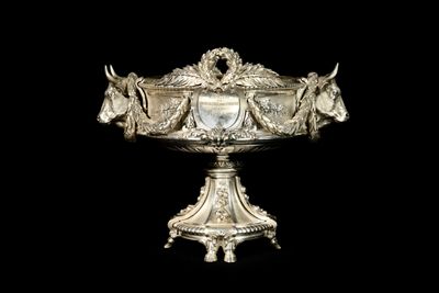 a silver bowl with horses on it on a black background