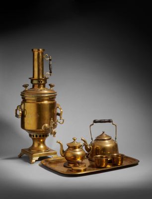 two brass teapots and a tray with a kettle on it