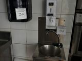 une photo de toilettes publiques avec un lavabo et des toilettes