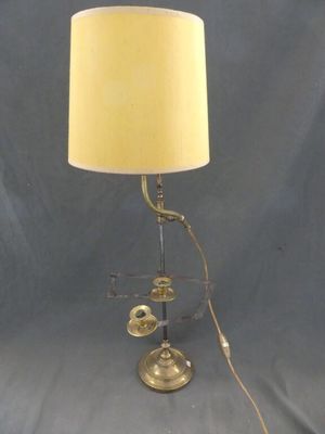 une lampe de table en laiton ancien avec un abat-jour blanc sur fond bleu