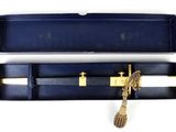 a black case with a gold handle and a white pen in it
