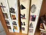 Plusieurs livres sont empilés sur une étagère devant une porte