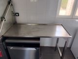 a stainless steel counter with a dishwasher in the corner