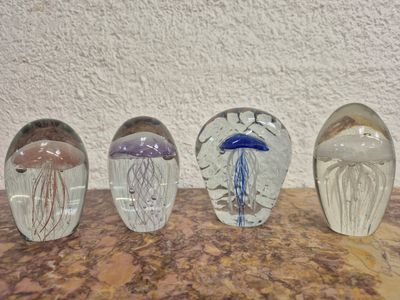 quatre coupes en verre posées sur une table en marbre