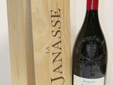 La bouteille de vin se trouve à côté d'une caisse en bois sur la table.