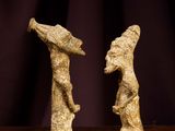 two figurines that are standing on a wooden table