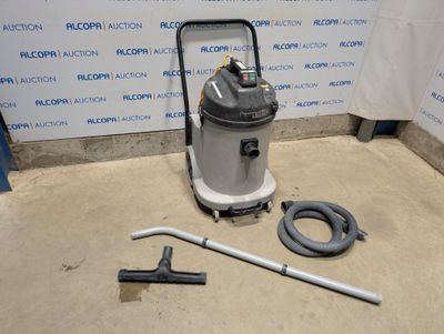 l'aspirateur est posé par terre à côté du tuyau