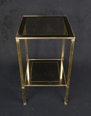 a black and gold side table with a glass top