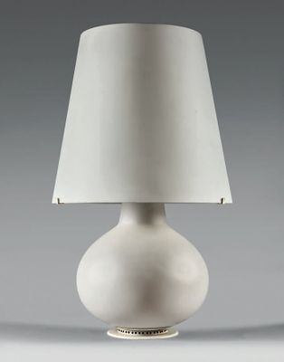 une lampe de table blanche surmontée d'un abat-jour blanc