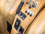beige leather interior of a car with buttons and steering controls