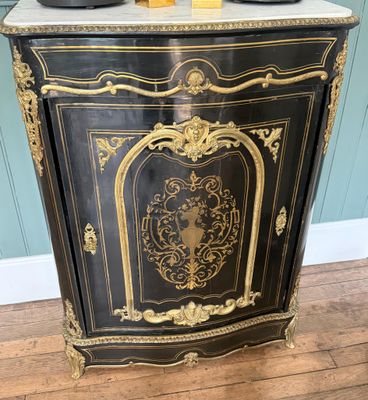 un meuble ancien peint en noir et or, doté d'un plateau en marbre