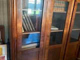 a wooden cabinet with glass doors in a room