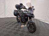 une moto qui est garée dans une pièce dont le sol est en damier