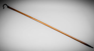 an old wooden walking stick with a black handle on a white background