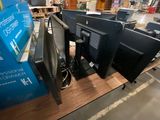 three computer monitors sitting on a table in a store