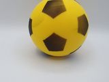 a yellow and black soccer ball on a white surface