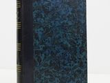 a blue book sitting on top of a white table next to a white wall