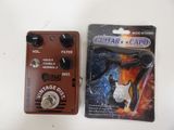 two guitar effects pedals sitting next to each other on a table
