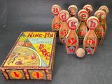 five wooden bowling pins and a box with a ball in it