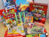 une pile de jouets et de jeux Pokémon posée sur une table en bois