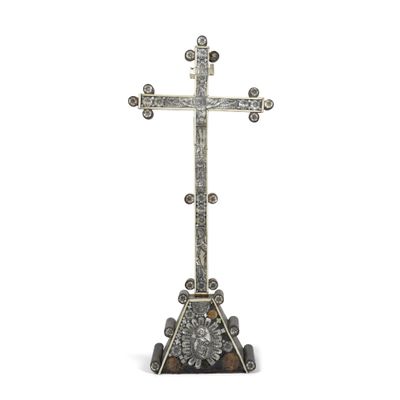 une image représentant une croix en argent posée sur un rocher
