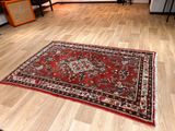 a red rug on the floor in a living room