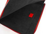 an open red and black zippered wallet on a white surface