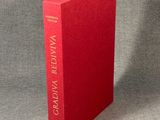 a red book sitting on top of a gray surface