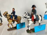 four figurines of men riding horses on display