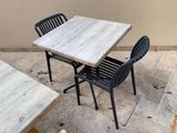 deux chaises et une table dehors, sur la terrasse