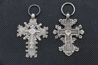 two silver crosses are shown on a black background