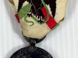 a small medal with an eagle on it on a white surface