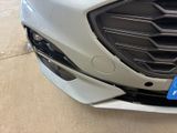 a close up of a car ' s grille with a blue tag on it