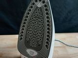 a black and white iron sitting on a wooden table