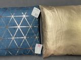 deux oreillers ornés de motifs dorés et bleus