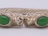 un gros plan d'une bague ornée de deux pierres vertes