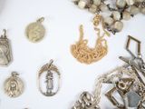 a lot of silver and gold jewelry on a white surface
