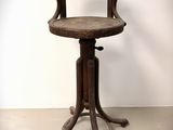 an old wooden chair with a wooden seat on a metal stand