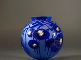 a blue vase that has flowers in it on a stand