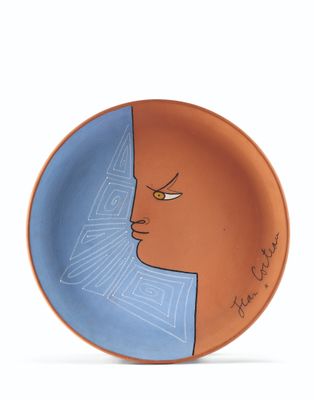 an orange and blue plate with a face painted on it