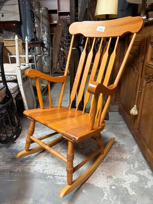 un fauteuil à bascule en bois qui se trouve dans une pièce