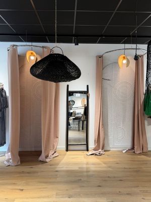une photo d'une pièce où se trouvent de nombreux vêtements suspendus à des cintres
