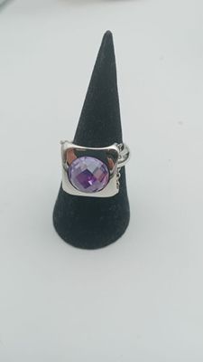 un gros plan d'une bague ornée d'une pierre violette montée sur un cône noir